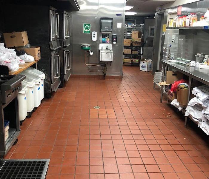 Commercial kitchen with tile floor and cooking items 